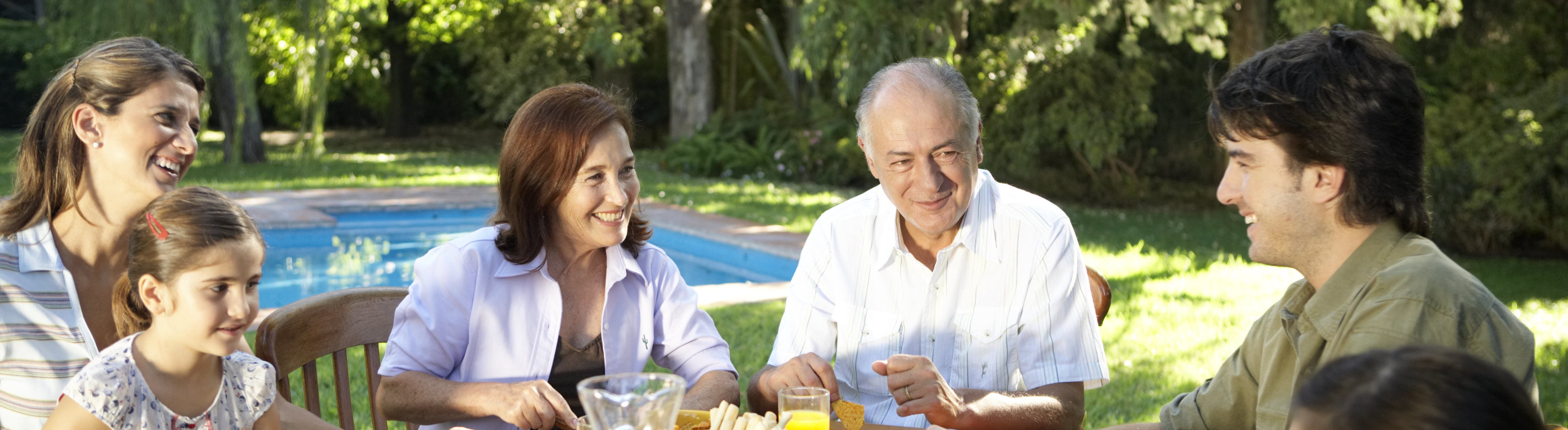 family sitting around table outside