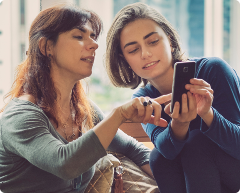 Two women looking at a phone screen.